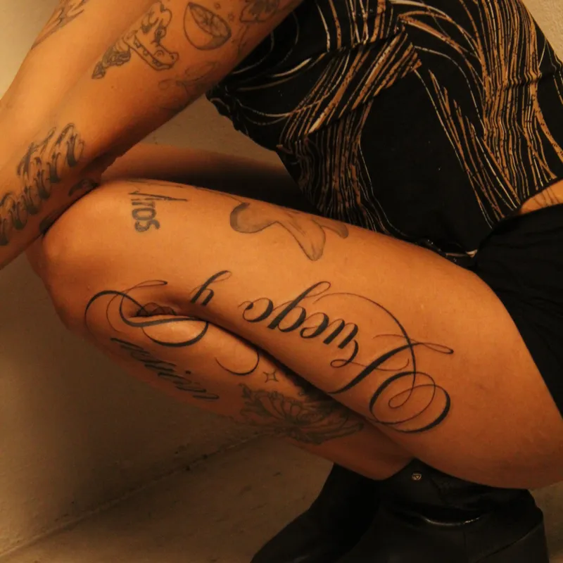 Inverted script calligraphy fine-line tattoo on forearm